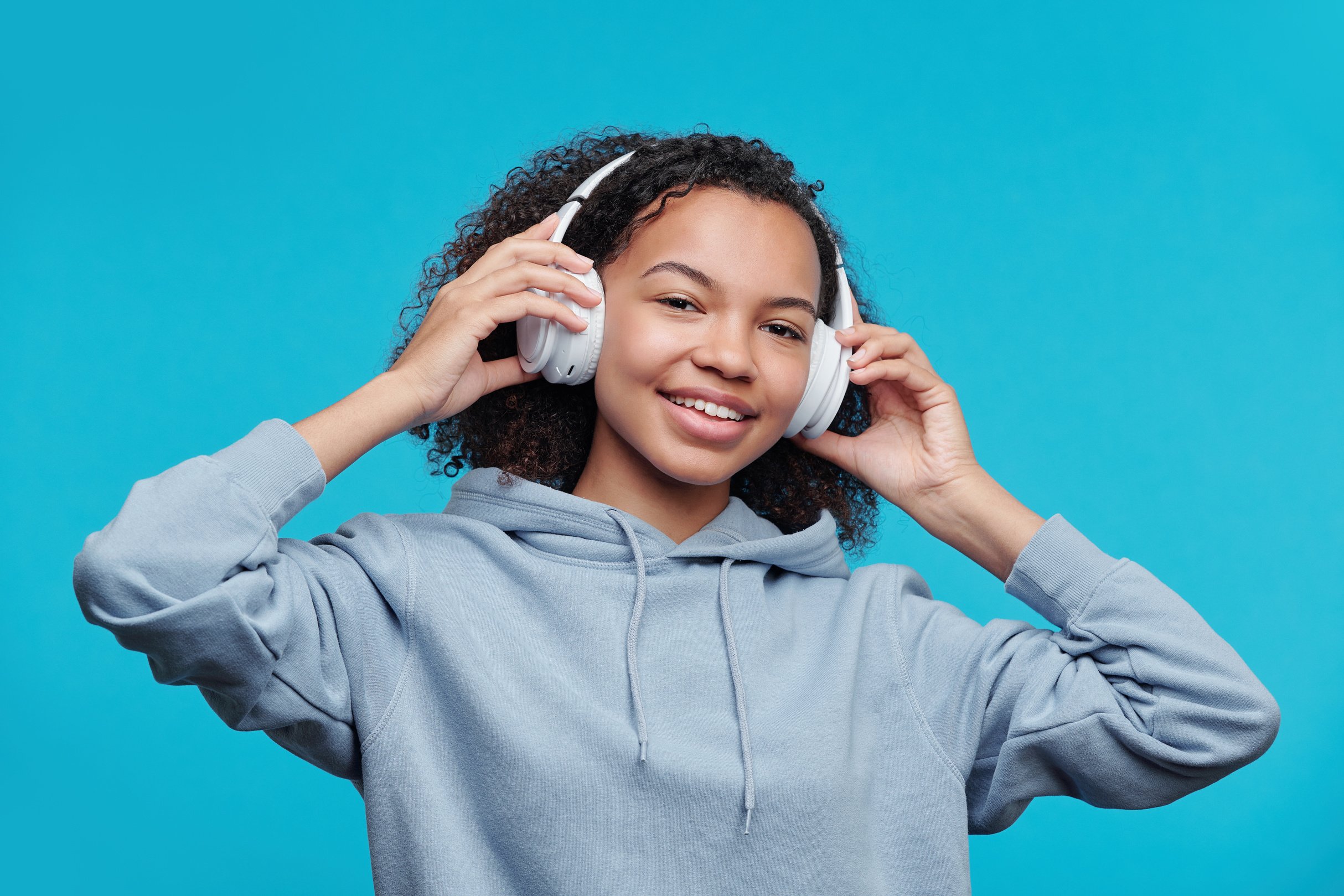 Happy black girl adjusting headphones